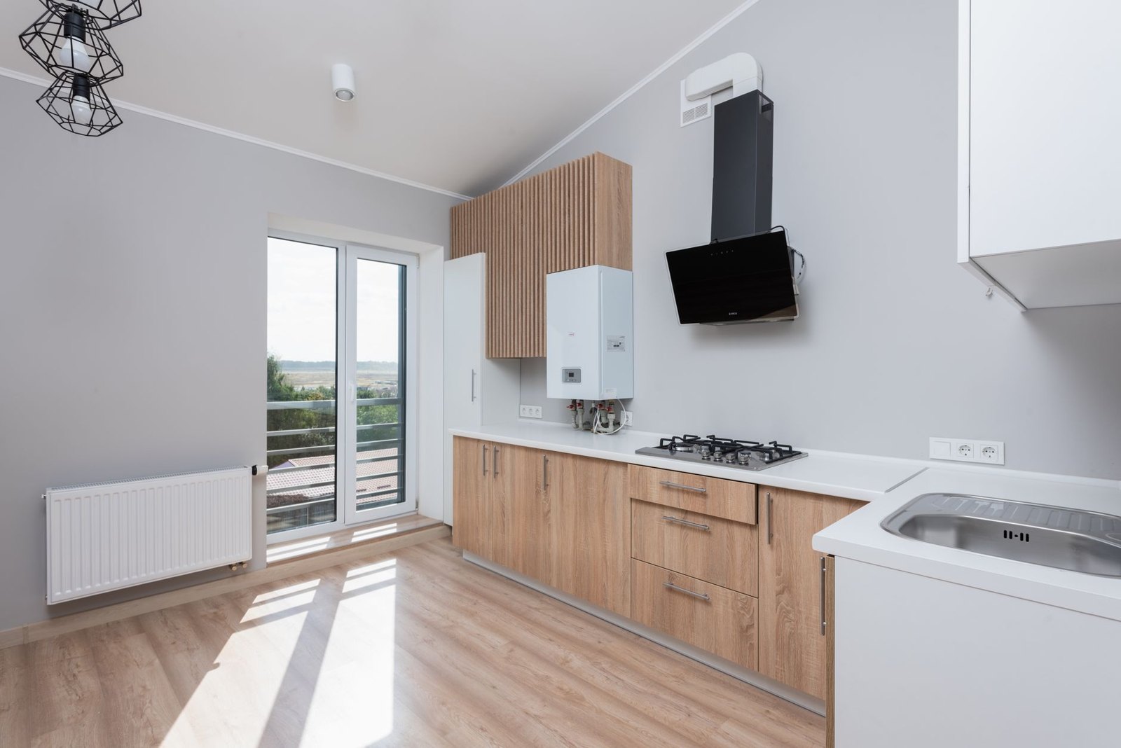 White wall-mounted gas boiler in a modern fitted kitchen